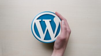 A hand curved around the WordPress logo