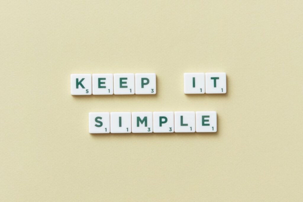 Scrabble tiles on a pale yellow background that spell out KEEP IT SIMPLE
