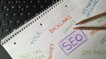 A notepad with SEO written on it surrounded by words relating to SEO, such as backlinks, images and keyword research.